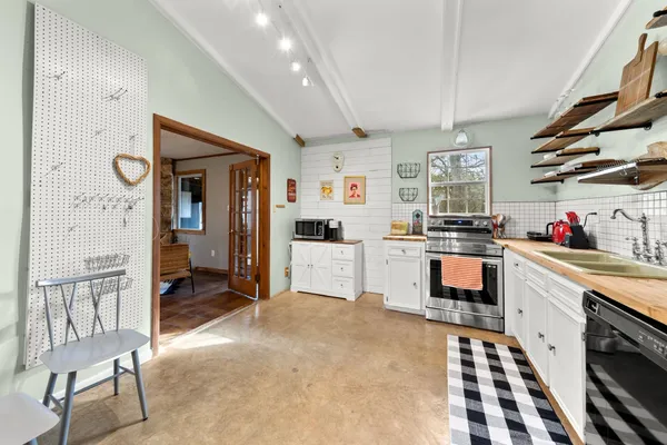 a kitchen with granite countertop a stove a sink and a refrigerator