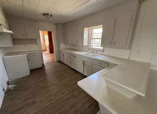 910 South 11th Street Slaton, TX 79364 - Photo 2 of 11 a large white kitchen with sink and wooden floor