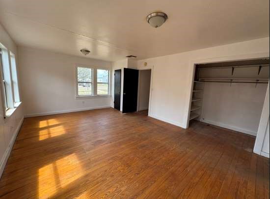 910 South 11th Street Slaton, TX 79364 - Photo 5 of 11 a view of an empty room with a window and wooden floor
