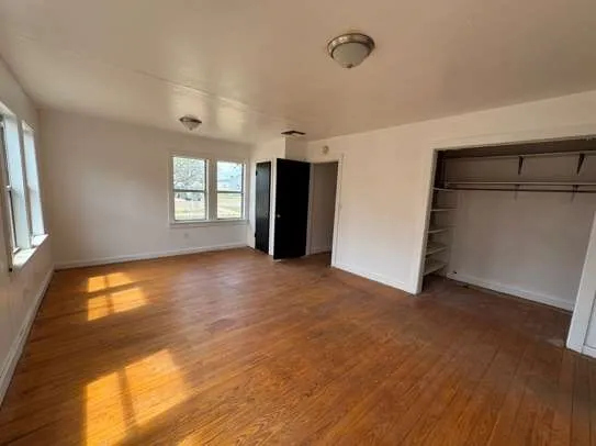 an empty room with windows and closet