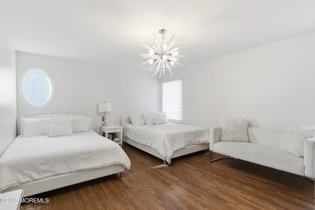 a bedroom with two beds and a chandelier