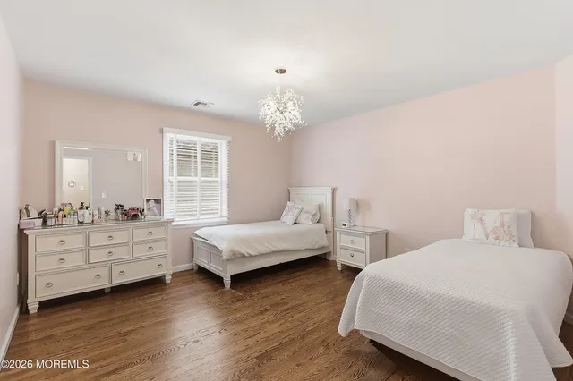 a bedroom with two beds and a chandelier