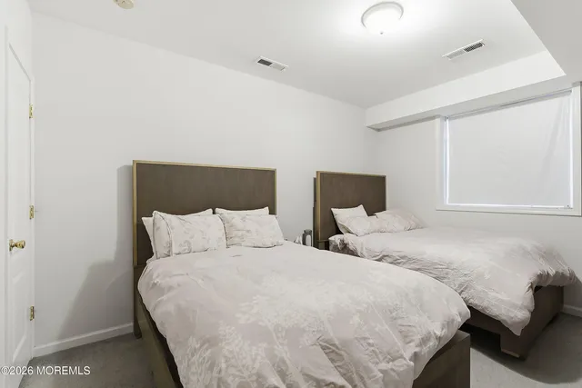 a bedroom with two beds and a window