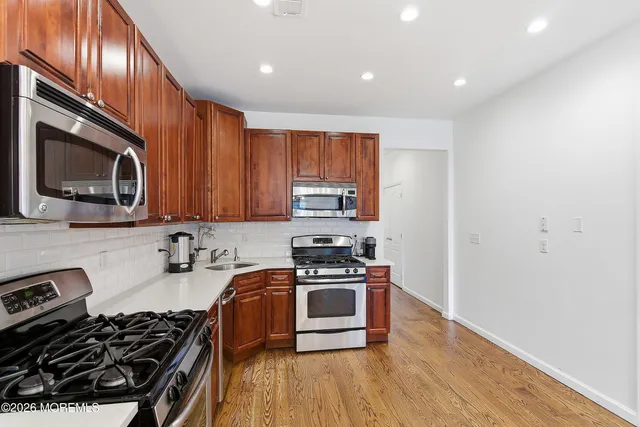 a kitchen with wooden floors and stainless steel appliances