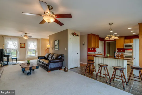a kitchen with stainless steel appliances a dining table chairs stove and sink