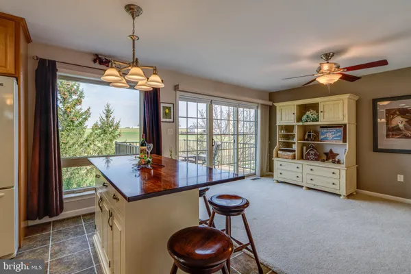 a kitchen with stainless steel appliances granite countertop a refrigerator a sink dishwasher a dining table and chairs with wooden floor