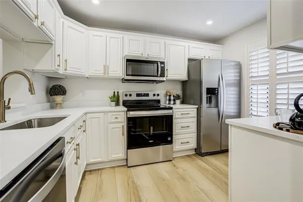 a kitchen with stainless steel appliances a stove sink microwave and cabinets