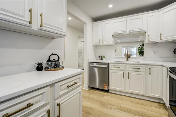 a kitchen with white cabinets and appliances