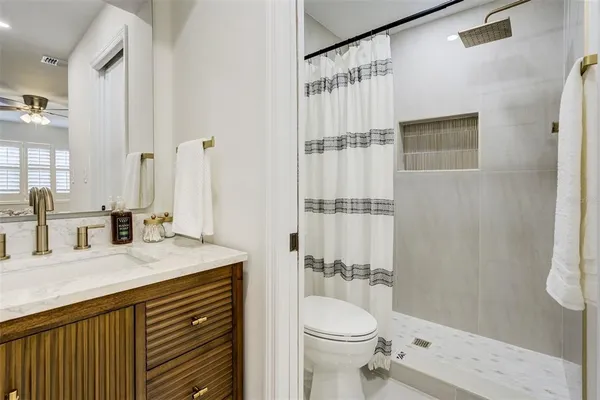 a bathroom with a sink a toilet and shower