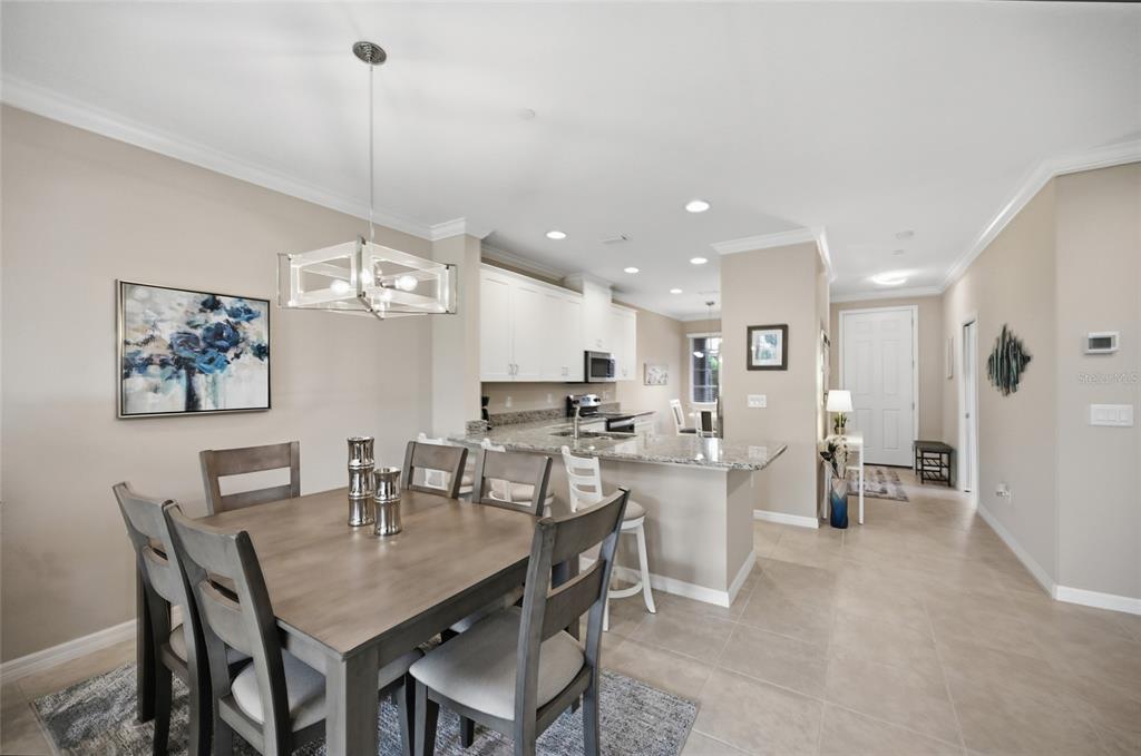 13837 Messina Loop, Unit 101 Bradenton, FL 34211 - Photo 14 of 51 a view of a dining room and livingroom with furniture wooden floor a chandelier