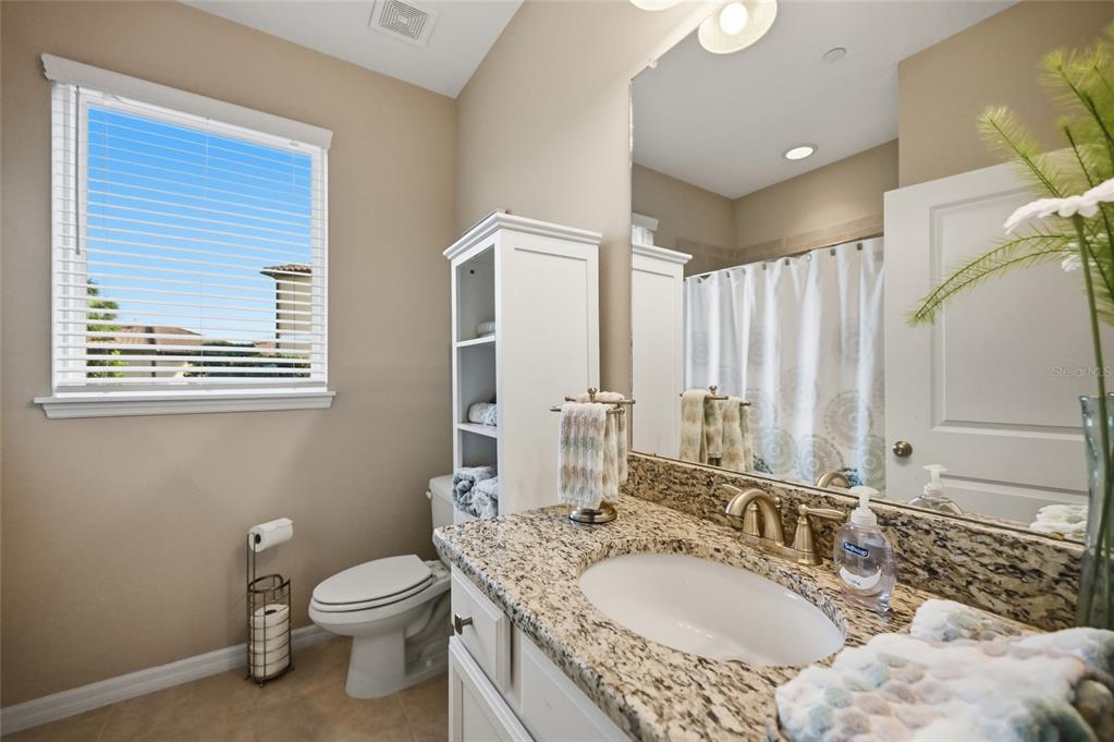 13837 Messina Loop, Unit 101 Bradenton, FL 34211 - Photo 21 of 51 a bathroom with a granite countertop double vanity sink a mirror and a toilet