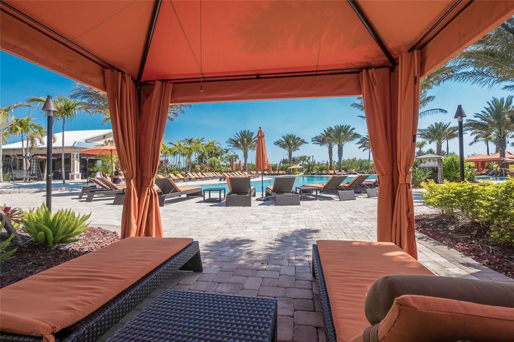 13837 Messina Loop, Unit 101 Bradenton, FL 34211 - Photo 36 of 51 a view of a patio with table and chairs potted plants with wooden floor