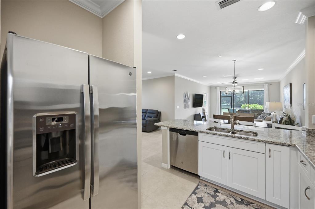 13837 Messina Loop, Unit 101 Bradenton, FL 34211 - Photo 8 of 51 a kitchen with a sink stainless steel appliances a counter top space cabinets and appliances