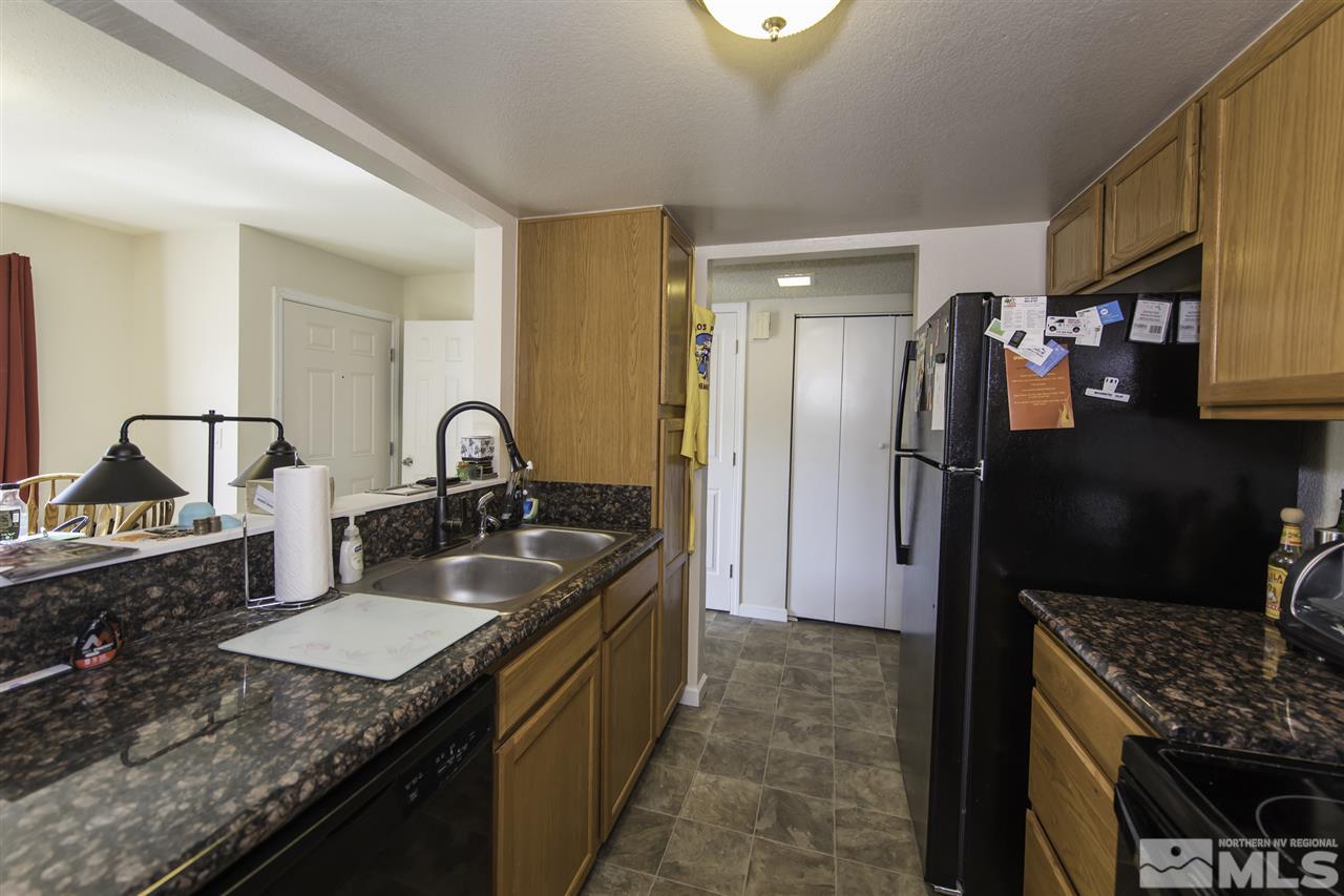 13860 Lear Boulevard Reno, NV 89506 - Photo 3 of 22 a kitchen with granite countertop kitchen island stainless steel appliances a sink stove and refrigerator