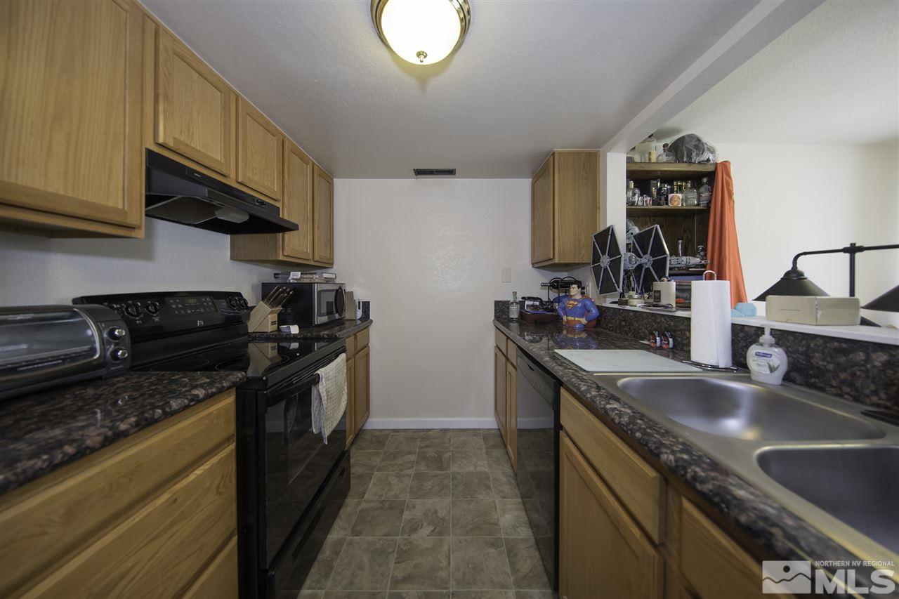 13860 Lear Boulevard Reno, NV 89506 - Photo 4 of 22 a kitchen with granite countertop stainless steel appliances a sink stove top oven and cabinets