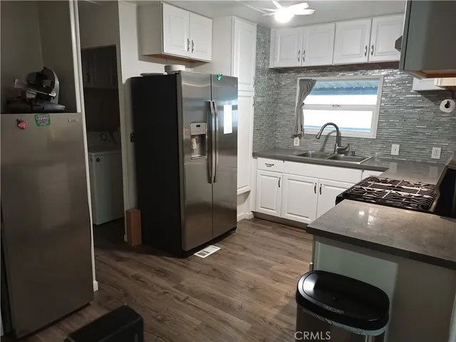 a kitchen with stainless steel appliances granite countertop a refrigerator a stove and a sink