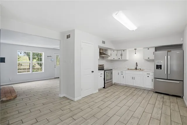 a kitchen with stainless steel appliances cabinets a sink and a window