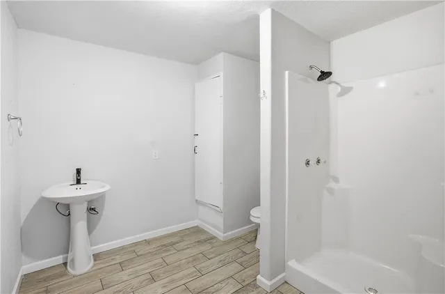 a bathroom with a sink a toilet and shower