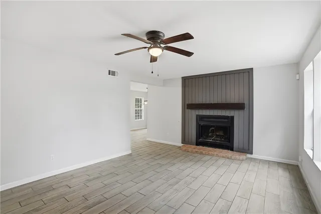 a view of empty room with wooden floor and fireplace