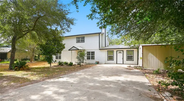 a front view of a house with a yard and trees