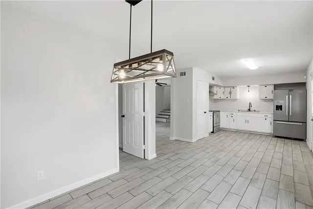 a view of a kitchen with refrigerator and window