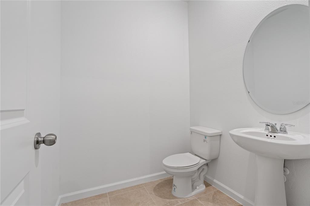 1141 Seaside Mist Trail Kissimmee, FL 34747 - Photo 11 of 30 a bathroom with a toilet a sink and mirror