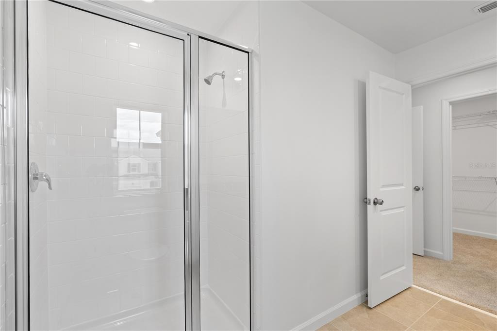 1141 Seaside Mist Trail Kissimmee, FL 34747 - Photo 27 of 30 a bathroom with a glass shower door