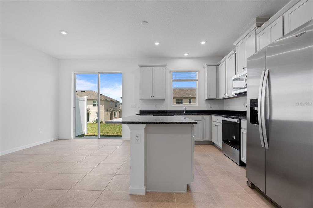 1141 Seaside Mist Trail Kissimmee, FL 34747 - Photo 5 of 30 a kitchen with stainless steel appliances granite countertop a refrigerator and a sink