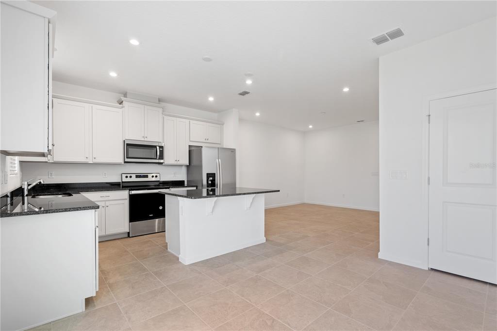 1141 Seaside Mist Trail Kissimmee, FL 34747 - Photo 7 of 30 a kitchen with cabinets and white appliances