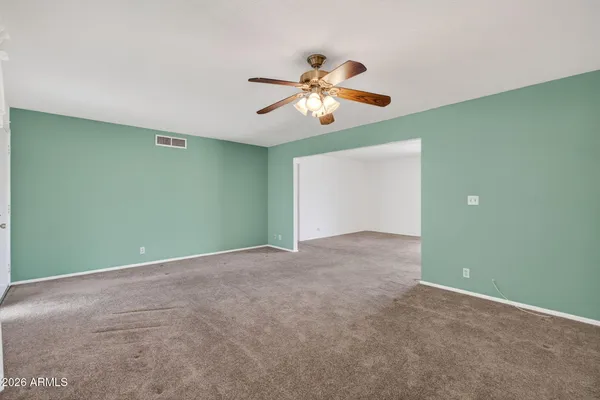 an empty room with closet and a chandelier fan