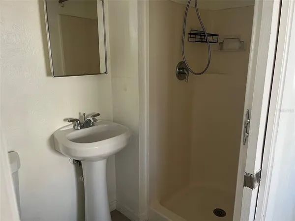 a bathroom with a sink a mirror and shower