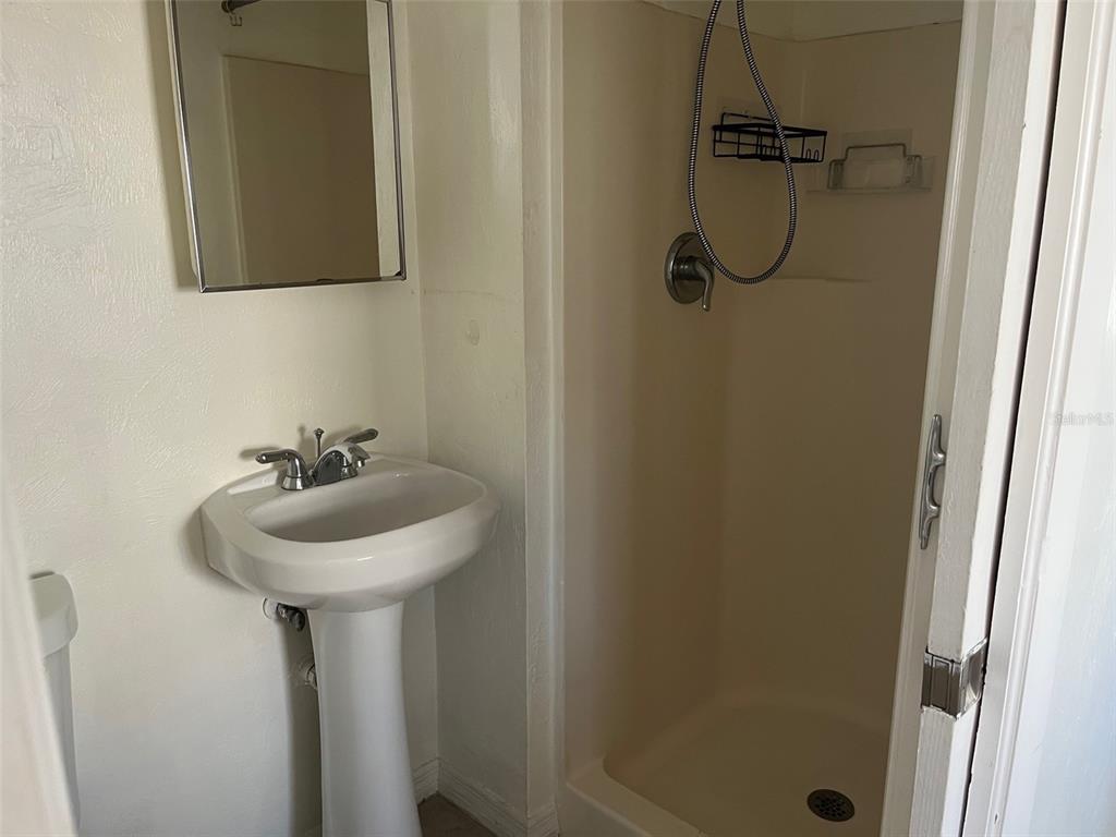 611 Ora Street, Unit 4 Daytona Beach, FL 32118 - Photo 6 of 8 a bathroom with a sink a mirror and shower