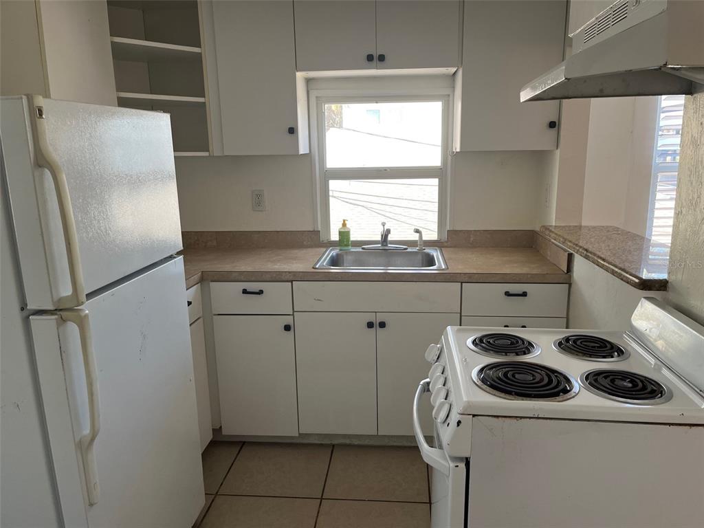 611 Ora Street, Unit 4 Daytona Beach, FL 32118 - Photo 7 of 8 a kitchen with a sink a stove and refrigerator
