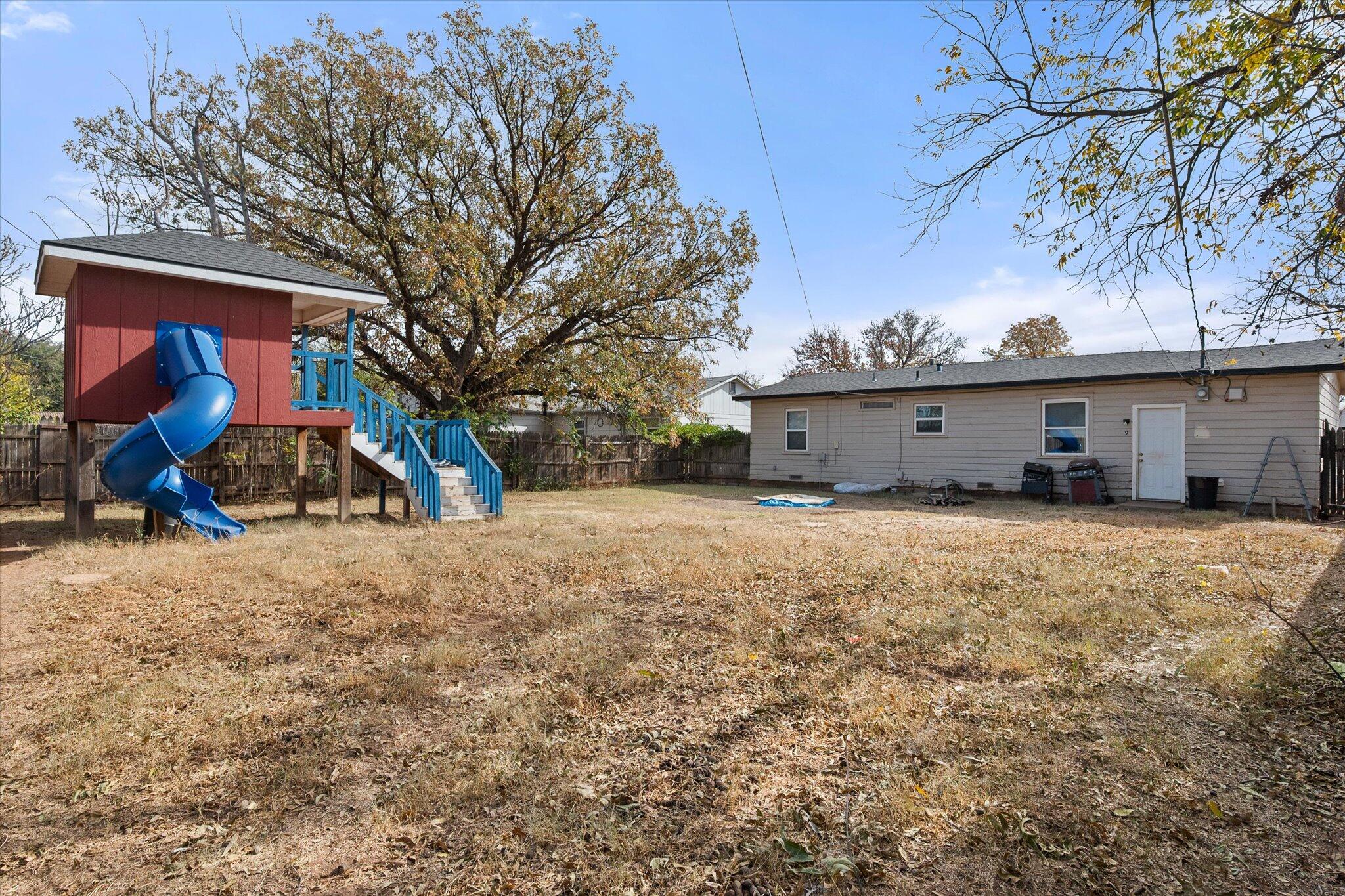 5006 42nd Street Lubbock, TX 79414 - Photo 16 of 19 a view of a house with a backyard and tree