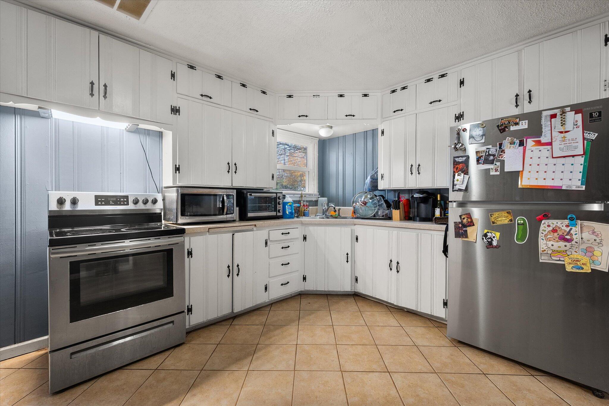 5006 42nd Street Lubbock, TX 79414 - Photo 7 of 19 a kitchen with stainless steel appliances granite countertop a refrigerator and a stove top oven