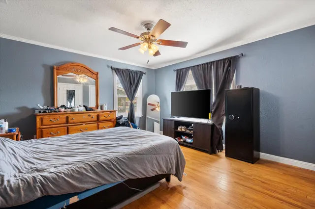 a bedroom with a bed and wooden floor