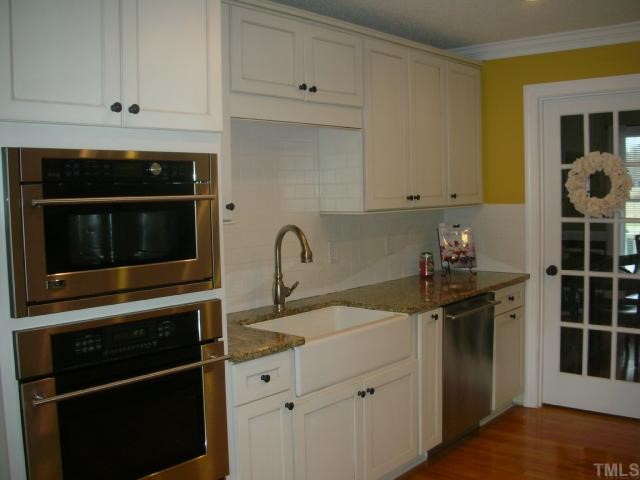 7617 Kennebec Road Willow Spring, NC 27592 - Photo 5 of 12 The kitchen continues with full tile back splash, deep country sink, custom cabinets with rope accents and designer knobs full of pull-outs. Convection/Microwave combination built-in. Custom plumbing fixture with pull-out sprayer. GRANITE