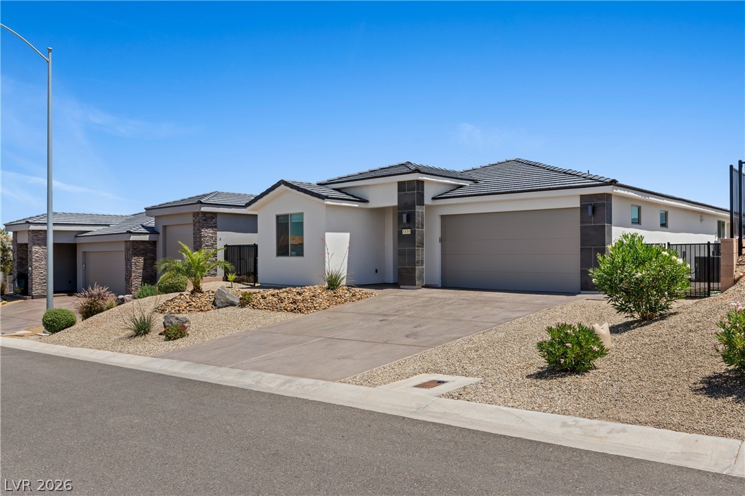 1436 Manassas Ridge Mesquite, NV 89027 - Photo 67 of 77 A well-maintained desert landscape frames this contemporary residence with an attached garage.