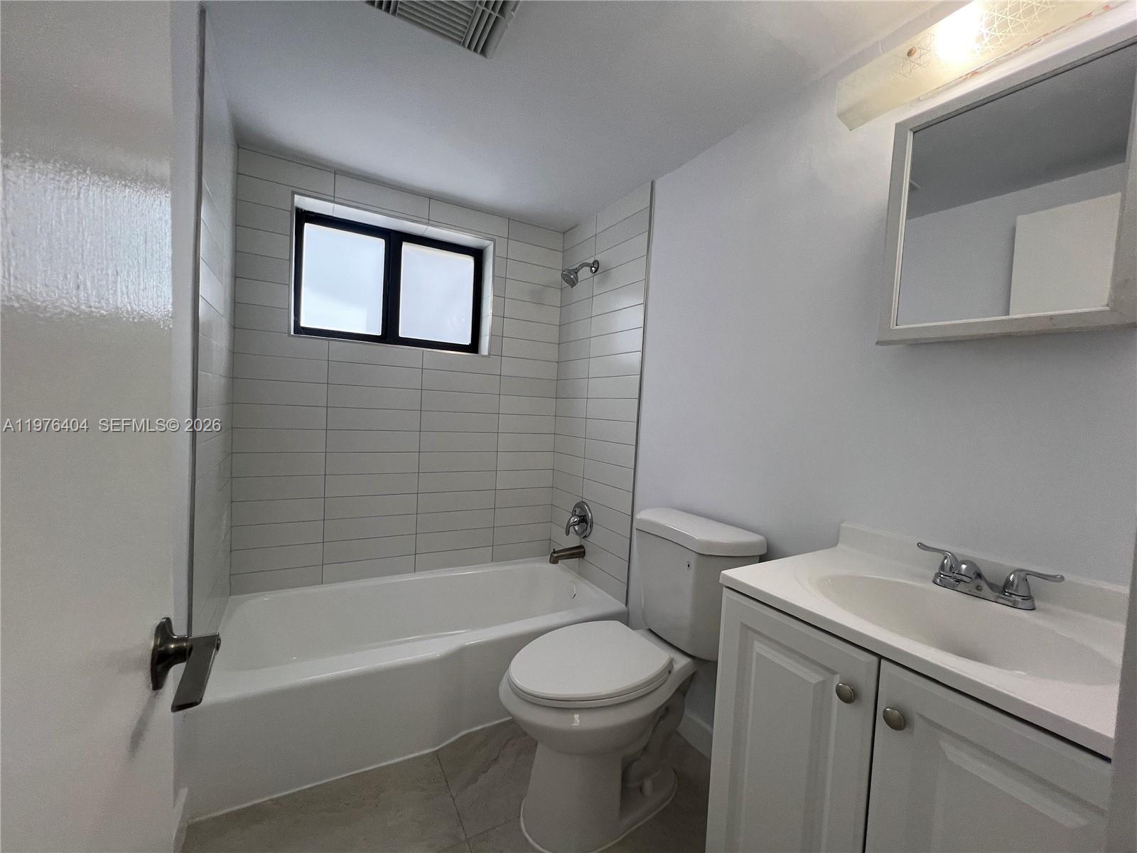 963 Northwest 5th Street, Unit 3 Miami, FL 33128 - Photo 6 of 12 a bathroom with a sink a toilet and shower