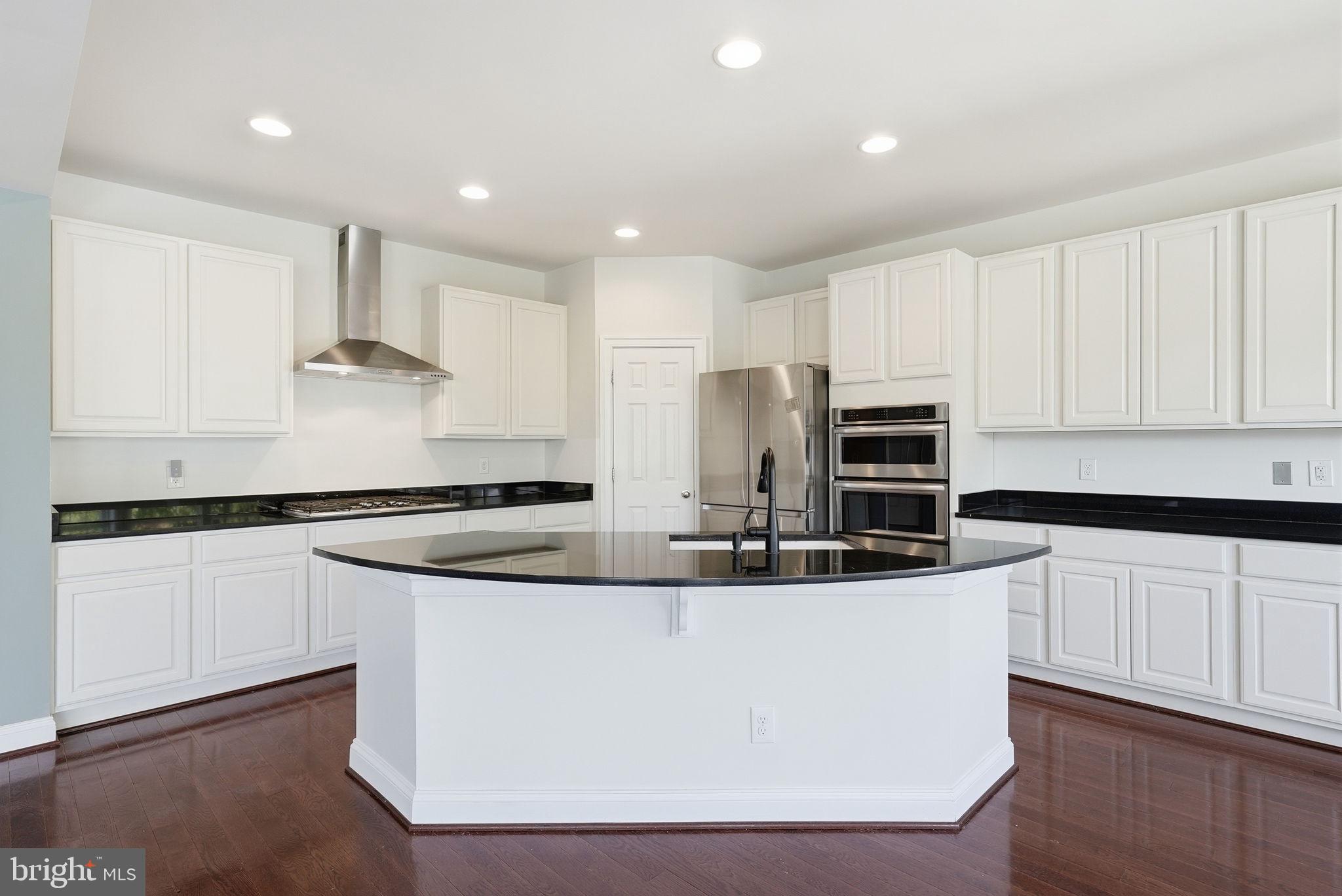 42330 Christophers View Terrace Ashburn, VA 20148 - Photo 14 of 46 a kitchen with kitchen island stainless steel appliances a sink a stove a refrigerator and white cabinets