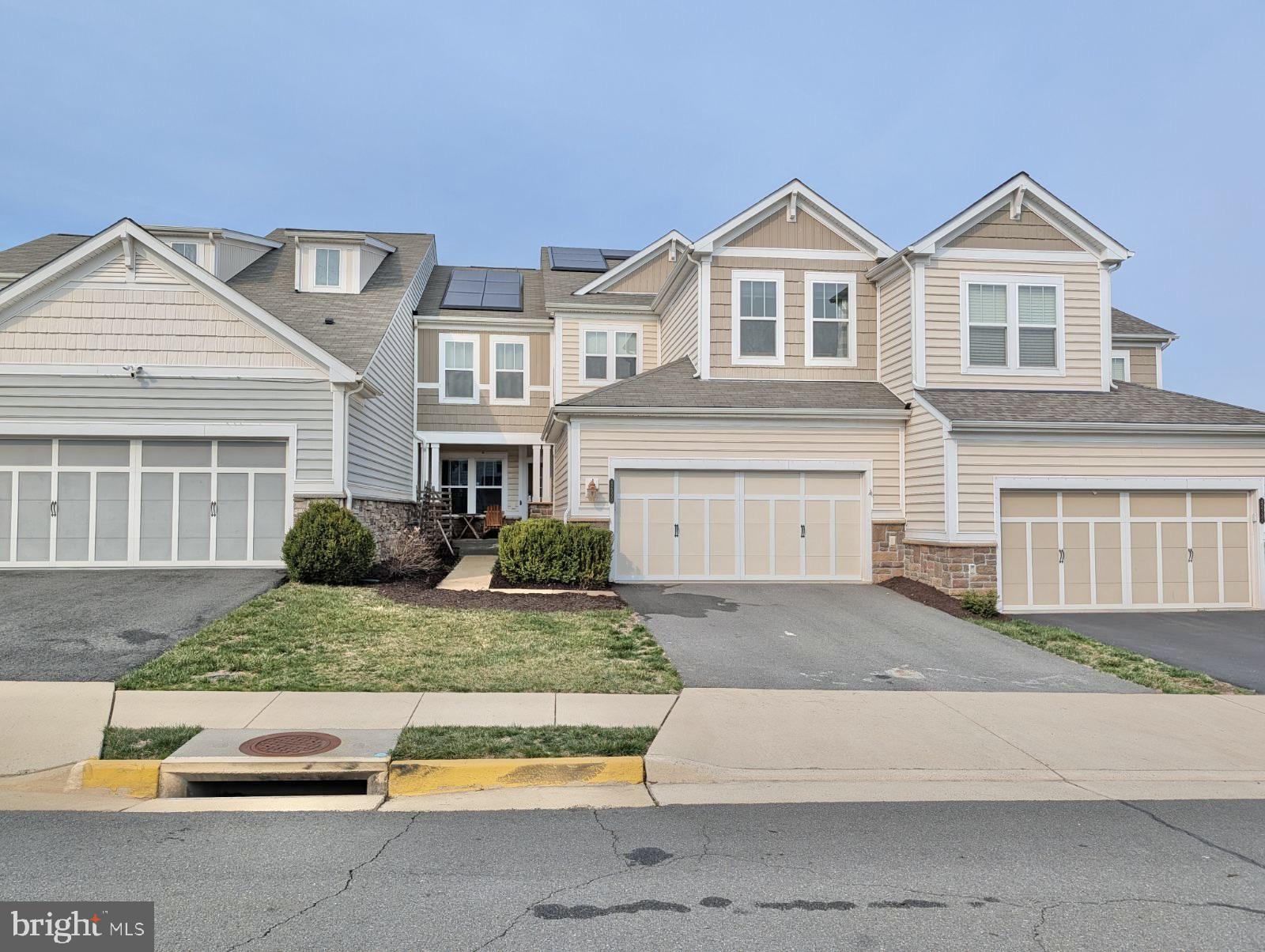 42330 Christophers View Terrace Ashburn, VA 20148 - Photo 2 of 7 a front view of a house with garage and glass windows