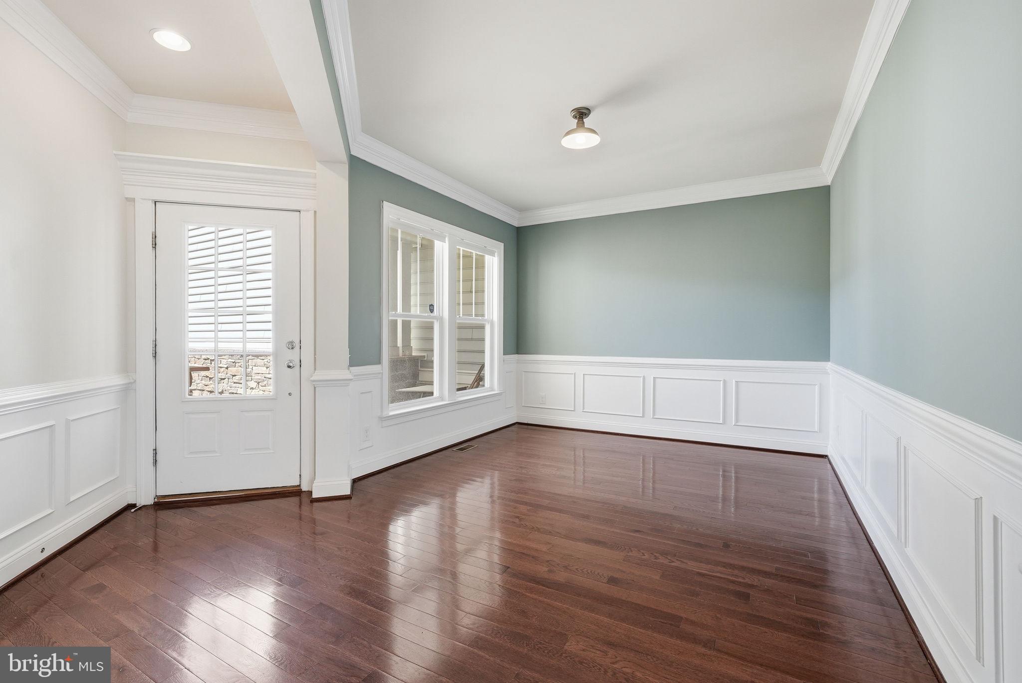 42330 Christophers View Terrace Ashburn, VA 20148 - Photo 3 of 46 an empty room with wooden floor and windows with curtains