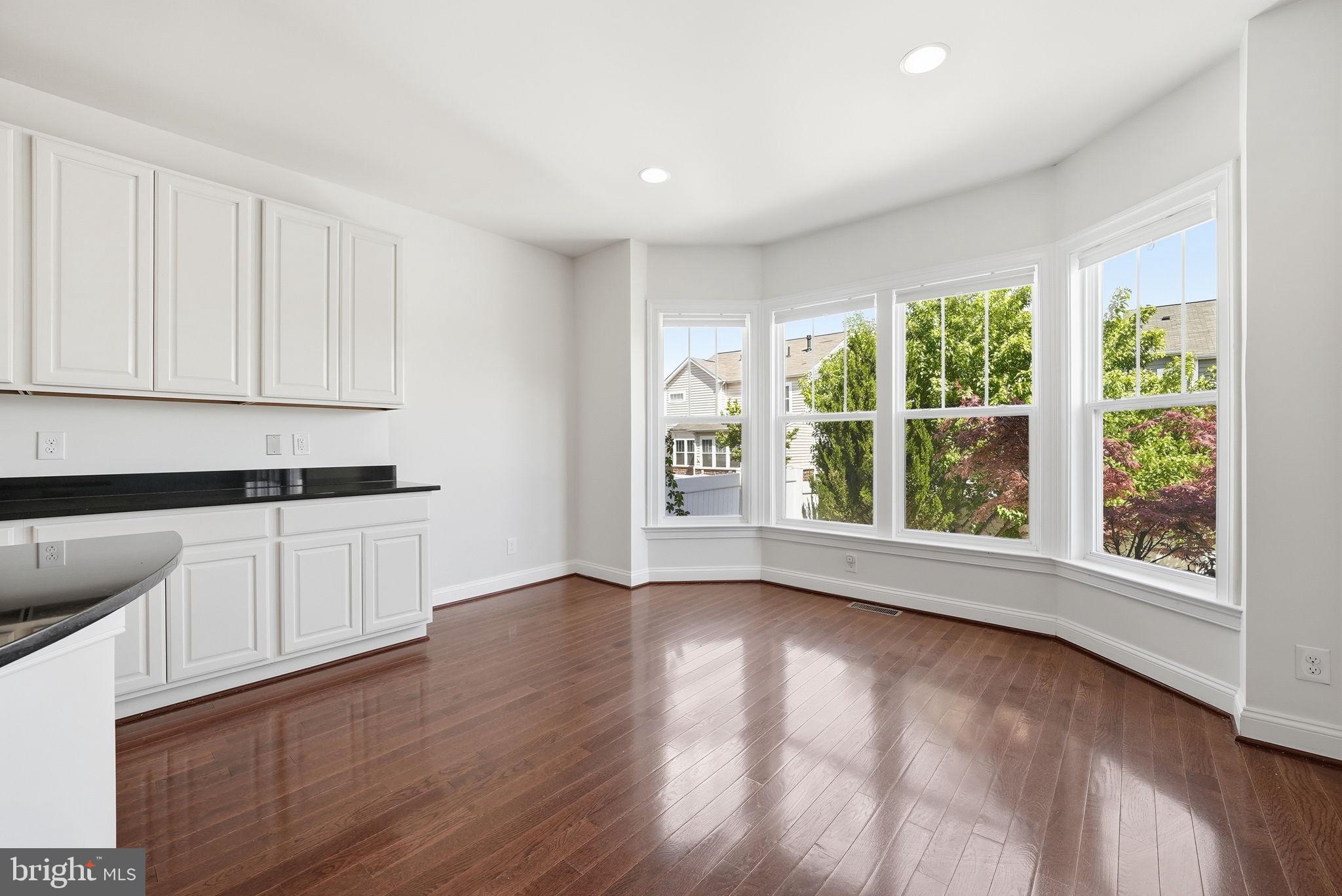 42330 Christophers View Terrace Ashburn, VA 20148 - Photo 9 of 46 a view of an empty room with wooden floor and a window