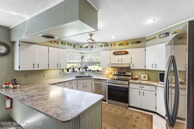 a kitchen with stainless steel appliances granite countertop a sink a stove and cabinets