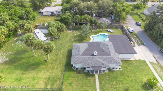 an aerial view of residential houses with outdoor space and lake view