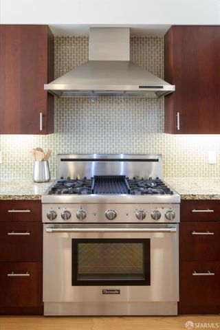 a kitchen with stainless steel appliances granite countertop a stove a refrigerator and a sink