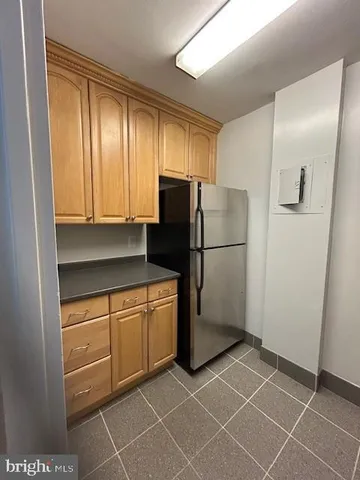 a kitchen with granite countertop a refrigerator and a sink