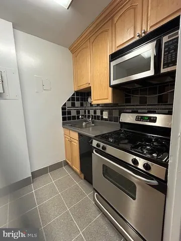 a kitchen with granite countertop a stove and a microwave