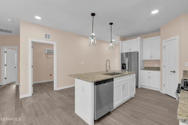 a kitchen with stainless steel appliances granite countertop a sink stove and refrigerator