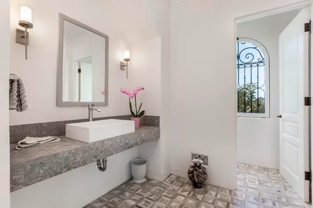 a bathroom with a granite countertop sink a mirror and a toilet